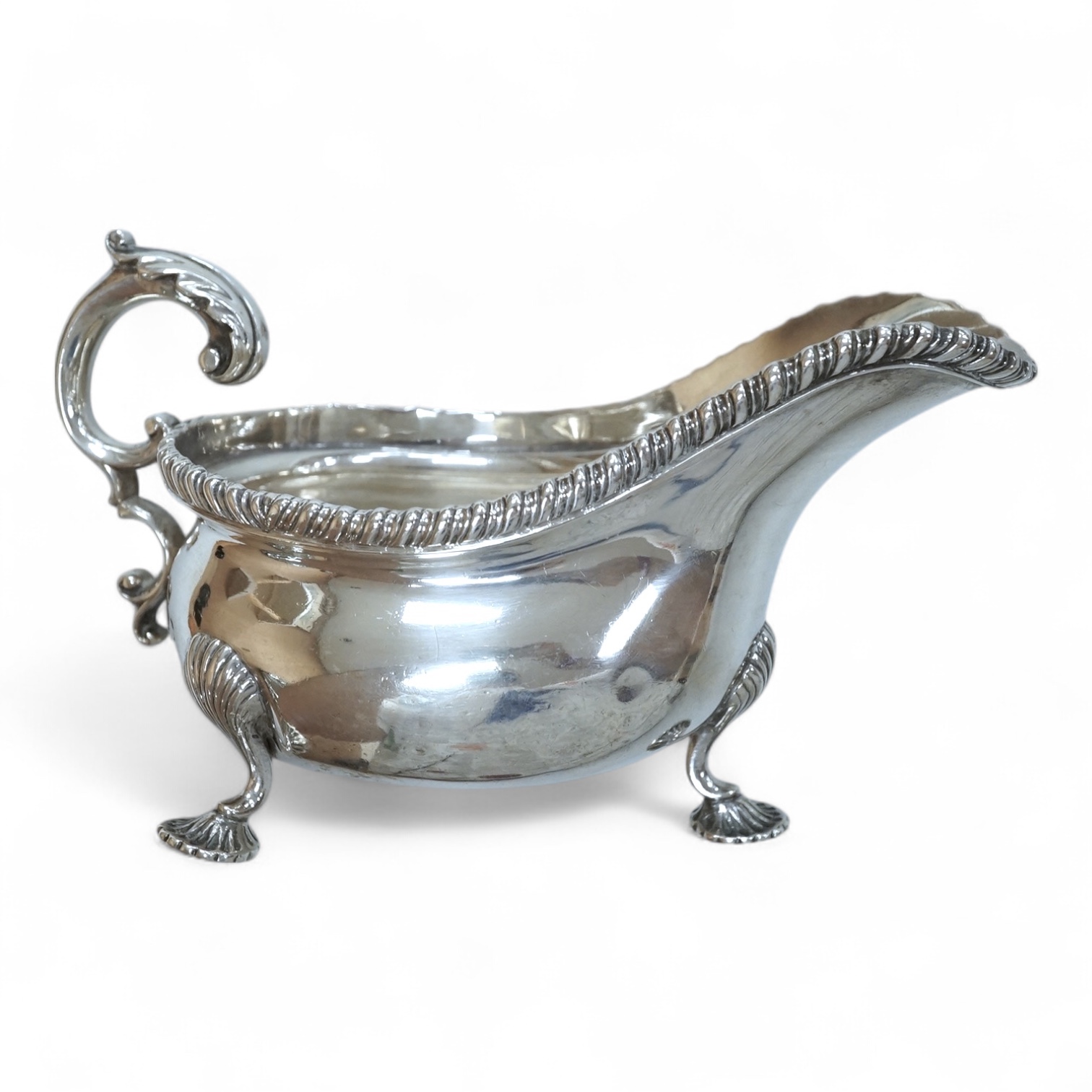 An Edwardian silver sauceboat, by The Goldsmiths & Silversmiths Co Ltd, London, 1903, with flying scroll handle and gadrooned border, length 16.3cm, 9.5oz.
